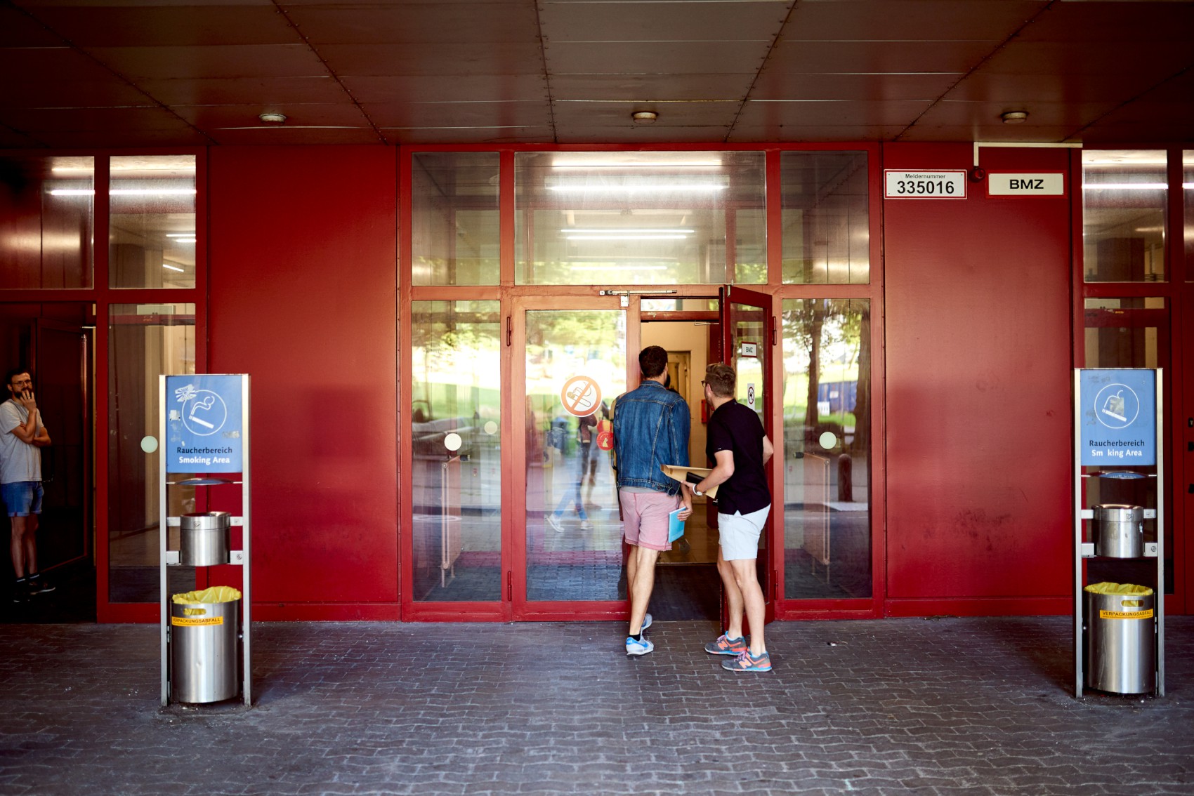 Studierende gehen durch rote Türen
